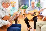 Cómo ayuda la música a prevenir el deterioro cognitivo Grupo de personas jubiladas tocando la guitarra