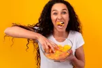 Vinculan comer patatas fritas y otras frituras a depresión y ansiedad Chica comiendo patatas fritas compulsivamente