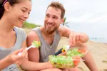 Dos jóvenes comiendo una ensalada saludable