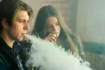 Una pareja de adolescentes vapeando