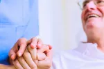 Un fármaco mejora la supervivencia con cáncer colorrectal metastásico Paciente de tercera edad feliz mientras da la mano a un médico