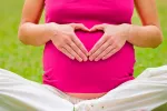 Combinar acupuntura y fármacos alivia las náuseas y vómitos del embarazo Embarazada con las manos en forma de corazón (representando la salud del bebé y suya)