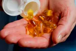 Ácidos grasos omega-3 vinculados a una progresión más lenta de la ELA Mano mostrando pastillas de omega-3