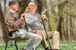 Dos señores mayores hablando sentados en el parque