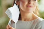Fin de la pandemia en España y de la mascarilla obligatoria Mujer se quita la mascarilla en la consulta del médico
