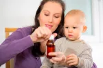 Paracetamol o ibuprofeno para niños Madre dando ibuprofeno a su hijo