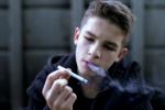 Chico adolescente fumándose un cigarrillo
