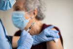Mujer anciana vacunándose contra la gripe y el COVID