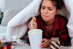 Mujer en la cama comiendo ultraprocesados