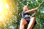 NIño jugando con una liana atada a un árbol