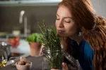 Mujer oliendo una planta de romero