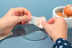 La membrana de la cáscara de huevo sería útil para la regeneración ósea Persona separando la membrana de la cáscara de un huevo