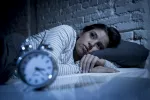 Así daña el corazón de las mujeres dormir solo 5 o 6 horas al día Mujer en la cama sin poder dormir por culpa del insomnio