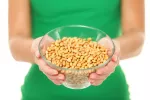 La dieta portafolio reduce el riesgo de enfermedad cardíaca e ictus Mujer sosteniendo un bol con granos de soja