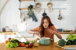 Mujer joven oliendo lo que está cocinando