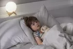 Niño pequeño en la cama despierto