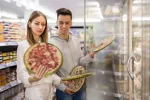 Comer ultraprocesados aumenta el riesgo de cáncer de cabeza y cuello Pareja comprando comida ultraprocesada en el supermercado