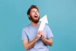 Vinculan ser demasiado optimista con menores capacidades cognitivas Joven optimista sosteniendo una flecha apuntando hacia arriba