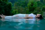 Practicar yoga nidra puede ayudar a mejorar el sueño y la memoria Mujer joven tumbada practicando yoga nidra