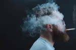 Fumar reduce el volumen del cerebro y lo envejece prematuramente Persona fumando con la cabeza envuelta en humo