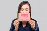 Mujer sosteniendo una hoja impresa con una lengua infectada por úlceras