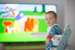 Abusar de la tele puede alterar la conducta sensorial de bebés y niños Bebé viendo la televisión mientras come