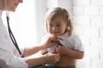 Cardiólogo auscultando a una niña con síndrome de Down