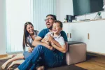Recibir buenos cuidados y cariño en la infancia protege el corazón adulto Familia feliz jugando en el salón de casa