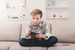 Los jugadores de videojuegos tienen más riesgo de tinnitus y sordera Niño jugando a videojuegos con los auriculares puestos