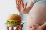 Mujer embarazada rechazando una hamburguesa