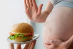 Mujer embarazada rechazando una hamburguesa