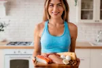 Descubren por qué el exceso de proteínas en la dieta daña las arterias Mujer joven mostrando una bandeja con alimentos ricos en proteinas