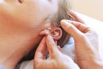 Mujer recibiendo acupuntura en la oreja