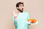 Comer carbohidratos refinados puede hacer que resultes menos atractivo Persona comiendo alimentos ricos en carbohidratos refinados