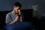 Dormir menos de 5 horas eleva el riesgo de diabetes aunque comas sano Joven mirando su smartphone por la noche en la cama
