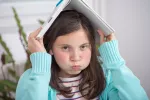 Un exceso de extraescolares perjudica la salud mental de los estudiantes NIña aburrida de hacer los 'deberes' en casa