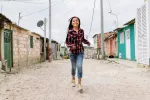 Niña corriendo por un barrio 'pobre' de una ciudad