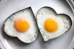 Los huevos fortificados no suben el colesterol y pueden mejorar la salud Huevos cocinados en unos moldes con forma de corazón