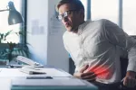 Un tipo de fibra puede agudizar la enfermedad inflamatoria intestinal Hombre se toca el abdomen con gesto de dolor