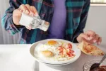 Si abusas del salero puedes tener un 40% más riesgo de cáncer de estómago Persona añadiendo sal a su plato de comida