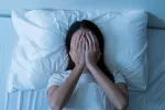 Pesadillas frecuentes alertarían de enfermedades autoinmunes como el lupus Mujer en la cama y con las manos en la cara porque ha tenido una pesadilla