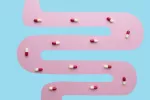 Nuevo antibiótico mata bacterias patógenas sin dañar la salud intestinal Ilustración de un intestino formando un camino con cápsulas de antibiótico