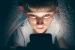 Revelan alteraciones en el cerebro de los adolescentes adictos a internet Adolescente mirando internet en la cama por la noche
