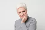 La periodontitis aumenta significativamente las probabilidades de sufrir un accidente cerebrovascular en personas menores de 50 años sin factores de riesgo. Mujer mayor con problemas bucales