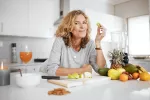 Esta es la dieta que puede ayudar a retrasar el envejecimiento del cerebro Retrato de una mujer de mediana edad comiendo comida saludable