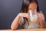 Los alimentos ricos en isoflavonas de soja mejoran la atención de los niños Niña bebiendo vaso de leche de soja