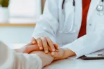 Por primera vez la terapia CAR-T elimina los síntomas del lupus en una niña Primer plano de manos de una doctora tranquilizando a su paciente adolescente