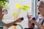 Descubren una hormona que fortalece los huesos y combatiría la osteoporosis Ancianas sanas sosteniendo un vaso de leche fresca, haciendo ejercicio