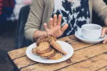 Cómo actúa el epitelio intestinal en la activación del sistema inmune en la celiaquía Mujer celíaca rechaza alimentos con gluten