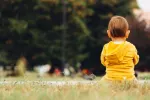La IA puede predecir autismo en niños menores de dos años Bebé sentado de espaldas sobre el césped